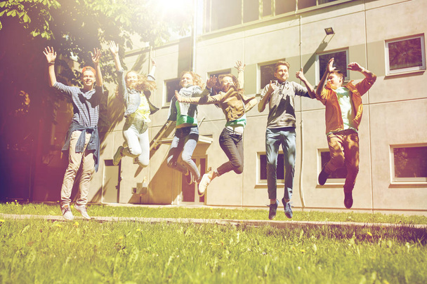 happy teenage students or friends jumping outdoors - Fotó, kép