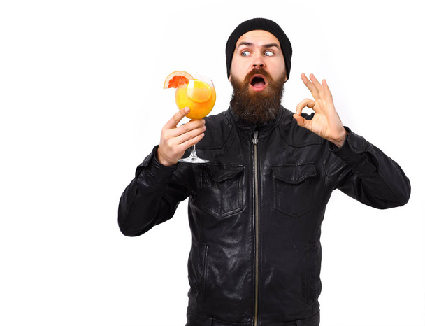 Brutal caucasian hipster holding alcoholic beverage or fresh cocktail - Fotó, kép
