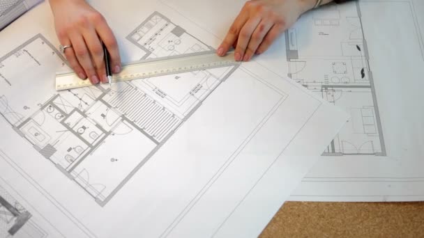 Over top view of architect working on blueprints plan - Footage, Video