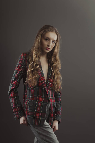 Stylish blonde woman posing for model tests  in checkered jacket - Fotó, kép