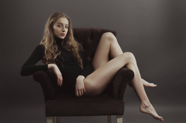 Glamorous young model posing for model tests sitting on a armcha - Photo, Image