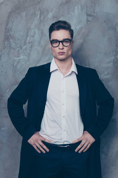Young attractive businessman in glasses put his hands on the bel - 写真・画像