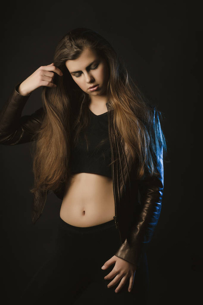 Гламурная молодая модель с длинными волосами позирует в студии с голубым
  - Фото, изображение
