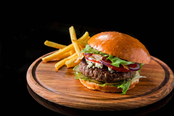 Cheeseburger with french fries on a wooden boar - Photo, Image