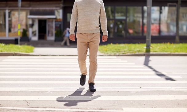 senior man walking along city crosswalk - Foto, Imagen