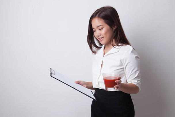 Asian business woman with clipboard and  tomato juice. - Fotó, kép