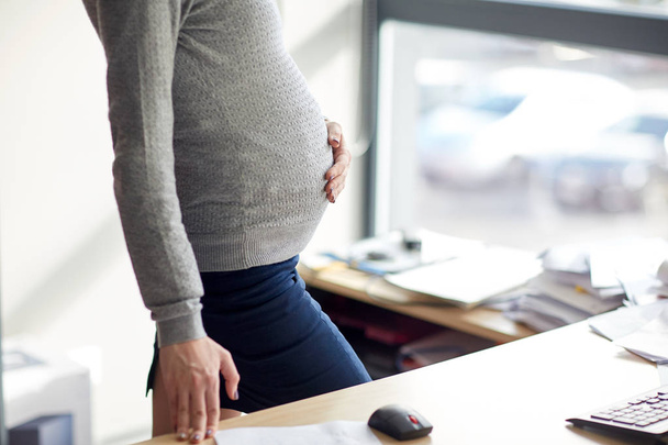 pregnant businesswoman with computer at office - Photo, image