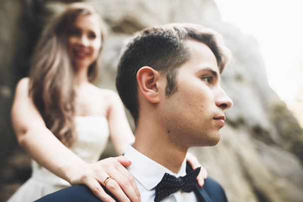 Happy wedding couple kissing and hugging near a high cliff - Photo, Image