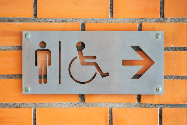 Чоловічий інвалідів особи туалет етикетки на червоної цегли стіни - Фото, зображення