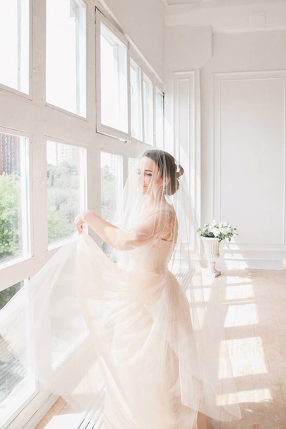 portrait of beautiful bride indoor. Fashion bride girl in gorgeous wedding dress in studio - Photo, image