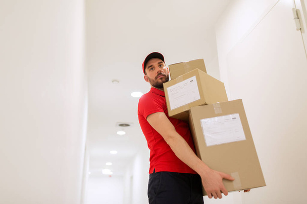 delivery man with parcel boxes in corridor - 写真・画像