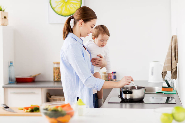 happy mother and baby cooking at home kitchen - Фото, зображення