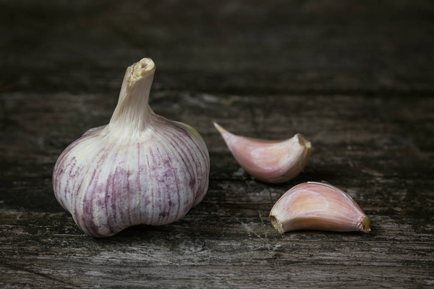 Garlic on an old wooden table - Foto, imagen
