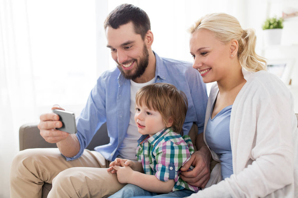 happy family with smartphone at home - Фото, изображение