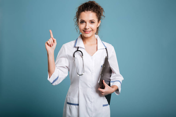 Medico in mantello bianco con stetoscopio e cartellone indicante dito
 - Foto, immagini