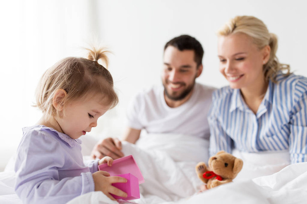happy family with gift box in bed at home - Photo, image