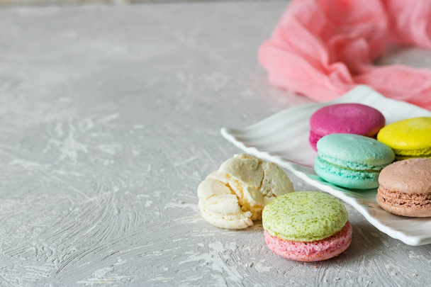 Different macaroons on a white plate place under the text - Photo, Image