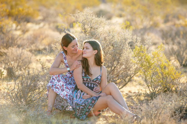 Porträt einer jungen Mutter und ihrer Tochter in einer Wüste aus rotem Roc - Foto, Bild