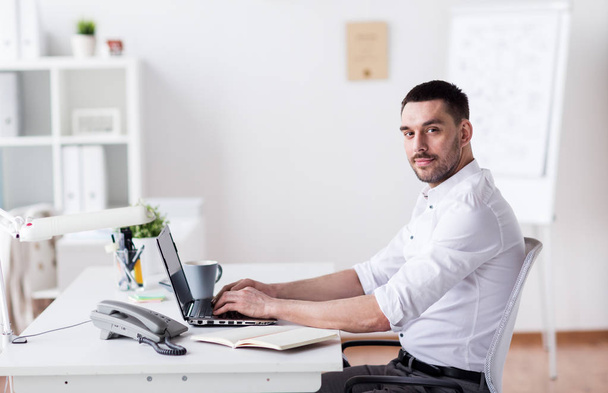 happy businessman with laptop at office - Zdjęcie, obraz