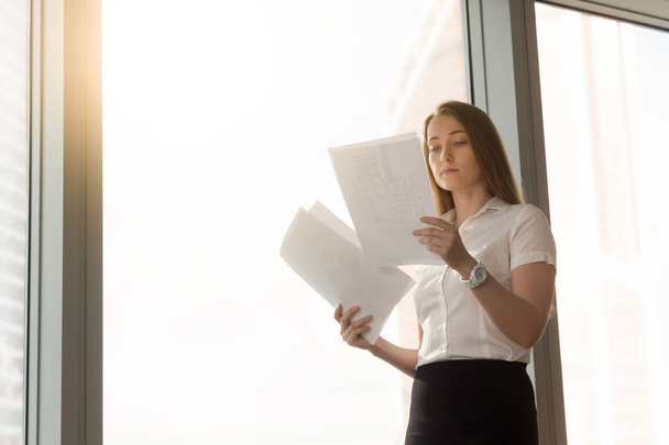 Businesswoman reading document with statistic data - Fotografie, Obrázek