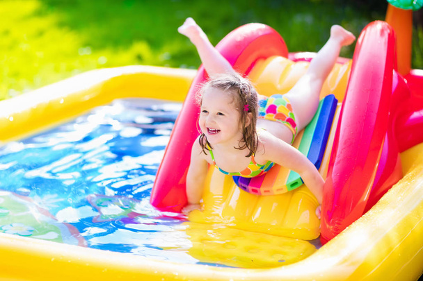 Niña jugando en piscina inflable jardín
 - Foto, imagen