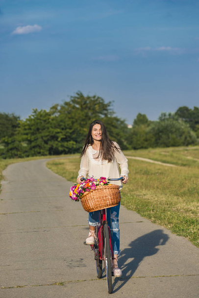 Young smiling woman rides a bicycle - Fotoğraf, Görsel