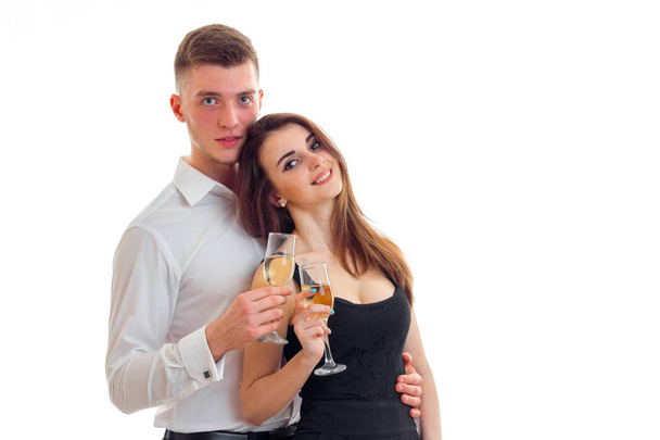 young guy standing next to a beautiful girl smiling and holding wine glasses - Foto, afbeelding