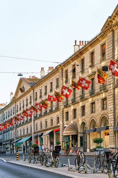 Bicycles at Rue Corraterie Street with Swiss flags in Geneva - Photo, Image