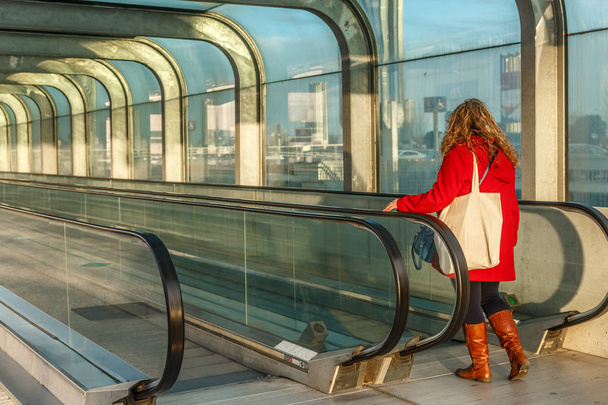 Жінка входить в ескалатори, за межами великого міста
 - Фото, зображення
