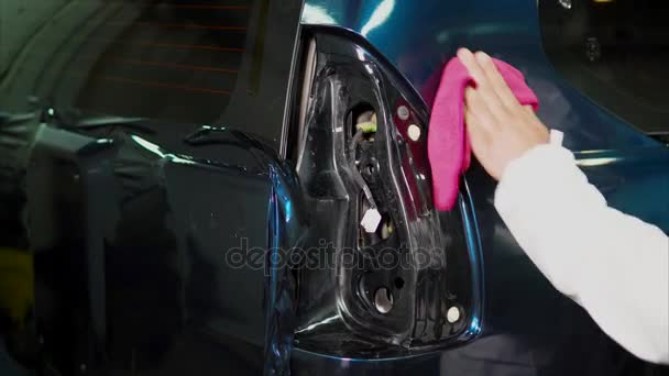 Master στο σταθμό υπηρεσία καθαρισμού αυτοκινήτου χρησιμοποιώντας κουρέλι μετά την εφαρμογή του ταινία βινυλίου - Πλάνα, βίντεο