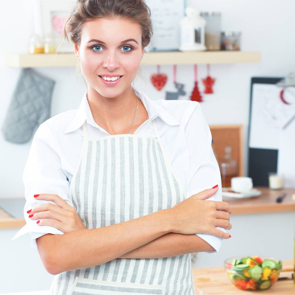 Smiling young woman in the kitchen,standing on christmas background - Fotó, kép