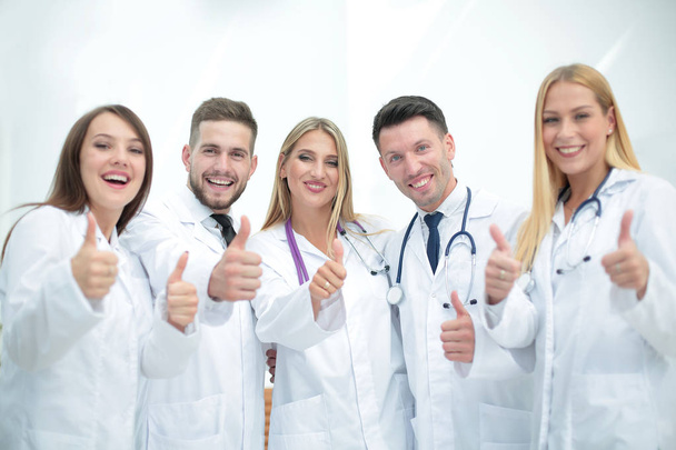 Smiling team of doctors at hospital making selfie and showing th - Photo, Image