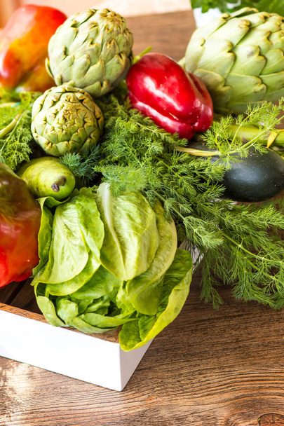 Variety of green vegetables and fruits in a crate on the table - Valokuva, kuva