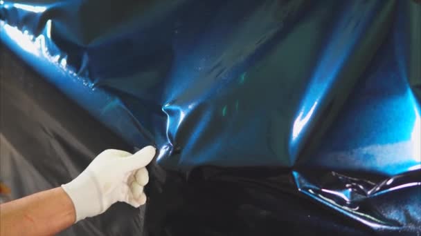 Close-up shot van de handen van de meesters in het tankstation vinyl op de machine gezet. - Video
