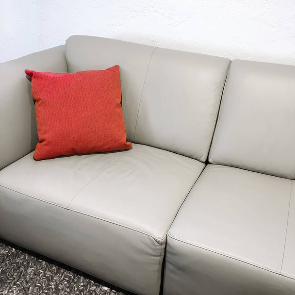 Простой кожаный диван с красной подушкой
 - Фото, изображение