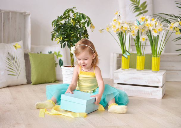 Beautiful little girl with gift box in a spring decor - Photo, Image