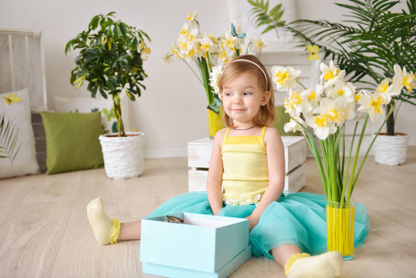 Beautiful little girl with gift box in a spring decor - Foto, Bild