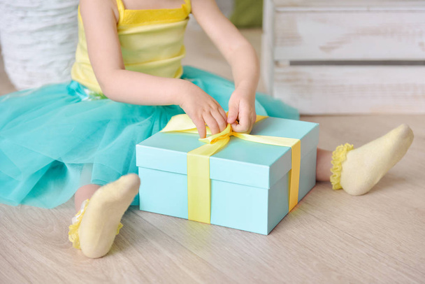 Beautiful little girl with gift box in a spring decor - 写真・画像