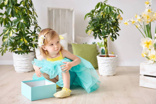 Beautiful little girl with gift box in a spring decor - Zdjęcie, obraz