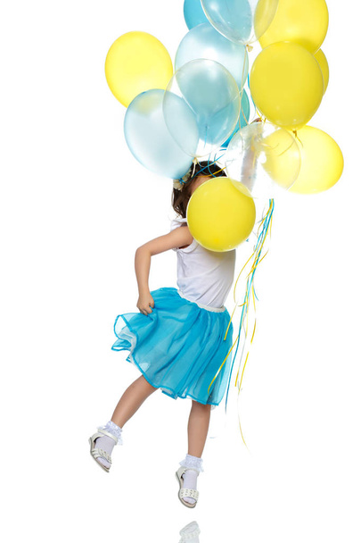 Little girl with multicolored balloons. - Фото, изображение