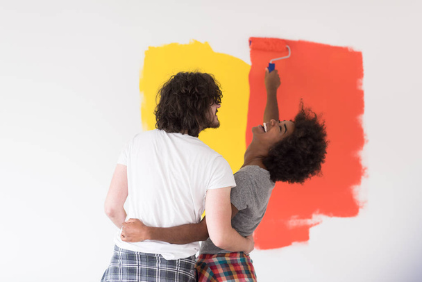 multiethnic couple painting interior wall - Zdjęcie, obraz
