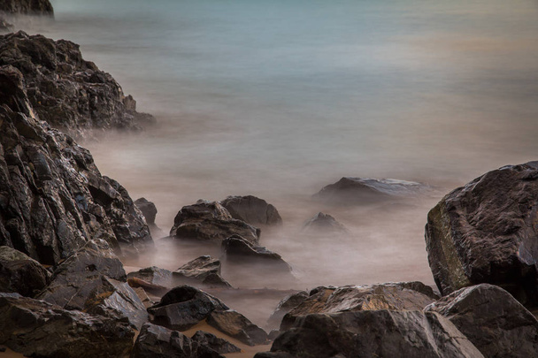 Lange blootstelling rotsen en golven - Foto, afbeelding
