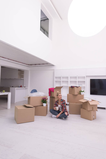 woman with many cardboard boxes sitting on floor - Фото, зображення