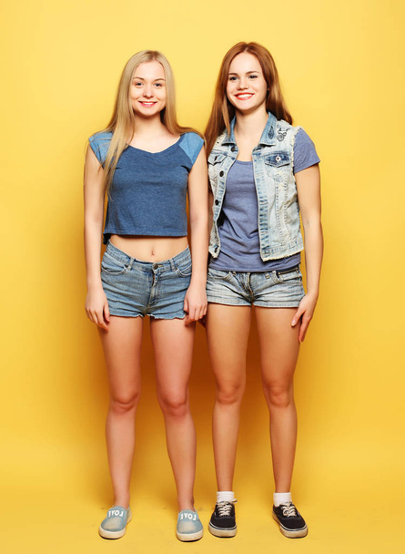 lifestyle portrait of two young  girls best friends jump over ye - Foto, imagen