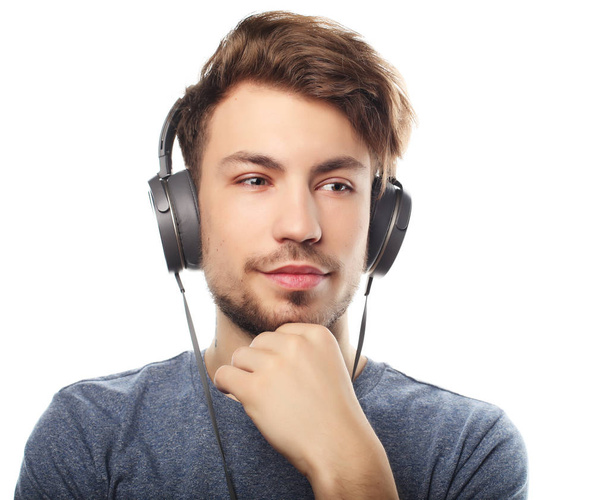 Handsome young man wearing headphones and listening to music. - Foto, Imagem