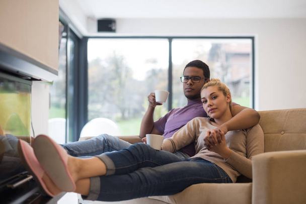 Young multiethnic couple  in front of fireplace - Foto, Bild