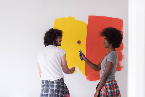 multiethnic couple painting interior wall - Foto, imagen