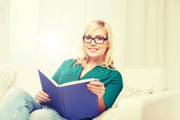 young woman in glasses reading book at home - Photo, image