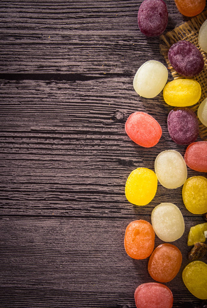 Кольорові фруктові цукерки на дерев'яному фоні
 - Фото, зображення