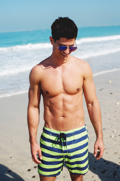 shirtless man op strand - Foto, afbeelding